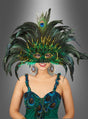 Eine Frau in einem aufwendig gearbeiteten „Samba Federschmuck Pfau“-Kostüm, bestehend aus einer auffälligen, von einem Pfau inspirierten Maske und passenden Ohrringen, steht vor einem grau abgestuften Hintergrund.