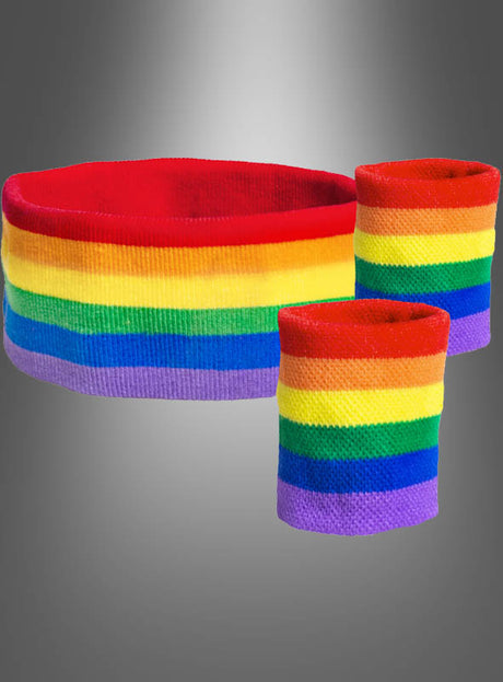 Ein regenbogenfarben gestreiftes Stirnband und zwei passende Armbänder aus dem Schweißband-Set „Regenbogen CSD“ sind vor einem grauen Hintergrund mit Farbverlauf abgebildet – ideale Accessoires für Feierlichkeiten beim Pride-Festival oder am Christopher Street Day.