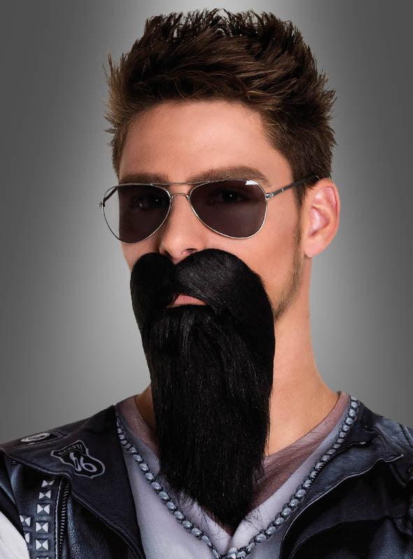 Ein Mann mit Sonnenbrille, einem schwarzen Biker-Vollbart und einer Lederweste steht vor einem grauen Hintergrund – perfekt für einen ausgefallenen Rocker-Kostüm-Look.
