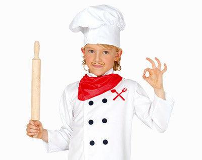Ein Kind, gekleidet wie ein Koch in weißer Uniform und mit Kochmütze, das in der einen Hand ein Nudelholz hält und mit der anderen die „OK“-Geste macht; es trägt einen roten Schal und einen aufgemalten Schnurrbart.