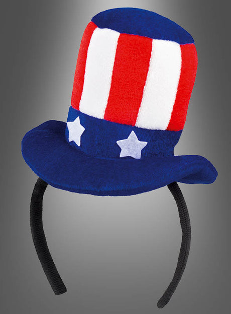 USA-Minizylinder mit Haarreif: Rot-weiß-blauer Plüsch-Uncle-Sam-Hut als Haarreif mit vertikalen Streifen und weißen Sternen auf einem blauen Band – ideal, um dein Uncle-Sam-Outfit zu vervollständigen oder deinem USA-Kostüm einen festlichen Touch zu verleihen, präsentiert vor grauem Hintergrund.