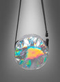Disco-Handtasche im 70er-Jahre-Stil, Umhängetasche in Silber – eine runde, schillernde Umhängetasche mit schwarzem Riemen, ideal als auffällige Disco-Handtasche, abgebildet vor einem grauen Hintergrund mit Farbverlauf.