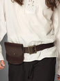 Eine Person trägt ein weißes Langarmhemd, eine schwarze Hose und einen braunen Gürtel, an dem die „Gürteltasche mit Gürtel für Piraten & Mittelalter“ an der Taille befestigt ist.