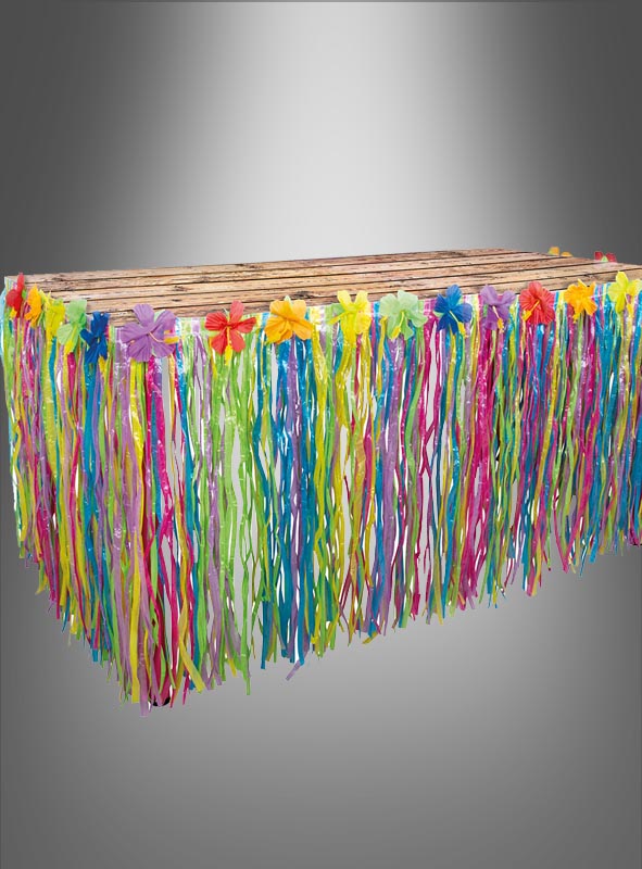 Ein rechteckiger Tisch, geschmückt mit dem „Tischrock 75 x 300 cm Sommerparty Hawaii“ mit bunten, herabhängenden Papierfransen und Kunstblumen – perfekt, um bei Ihrer nächsten Hawaii-Mottoparty oder Sommerparty-Dekoration einen Tischschmuck im tropischen Stil oder im Luau-Stil zu gestalten.