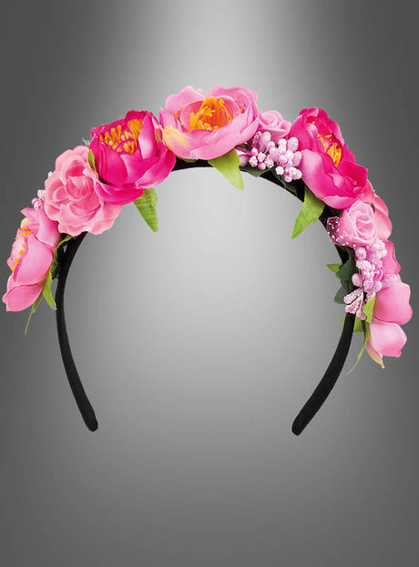 Das „Blüten Haarreif pink“ ist ein schwarzes Haarband, das mit künstlichen rosa und magentafarbenen Blüten sowie grünen Blättern verziert ist – perfekt als Blumenschmuck für ein Elfenkostüm – und auf einem grau abgestuften Hintergrund präsentiert wird.