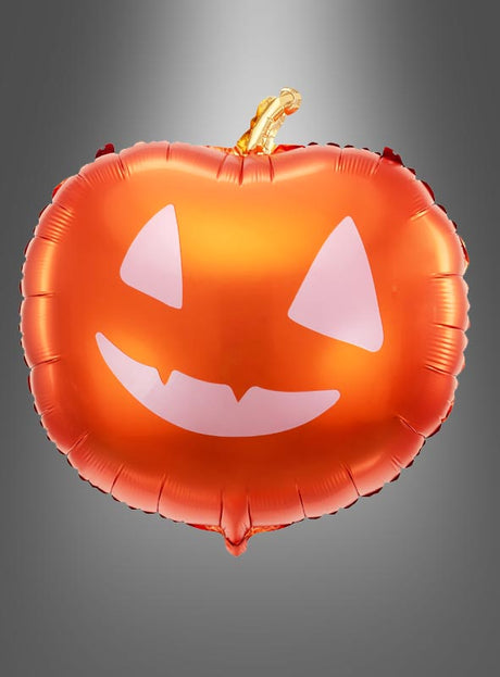 Ein fröhlicher, orangefarbener Folienballon in Form einer Kürbislaterne, der „Folienballon Kürbis Halloween Deko 40 cm“, schwebt vor einem grauen Hintergrund mit Farbverlauf – eine ideale Dekoration für Ihre Halloween-Feier.