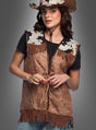 Eine Person, die einen braunen Cowboyhut, ein schwarzes T-Shirt und die „Cowboy Weste für Damen“ mit Kuhmuster an den Schultern trägt, posiert vor einem grauen Hintergrund und sorgt so für einen authentischen Western-Look.