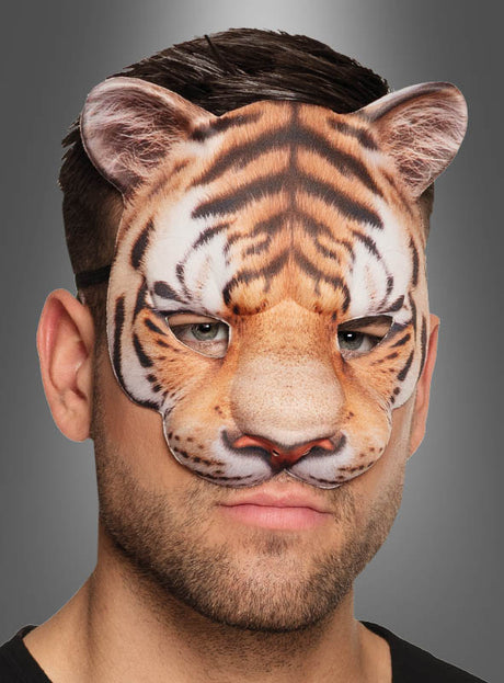 Eine Person, die die Unisex-Halbmaske „Tiger“ trägt, die den oberen Teil ihres Gesichts bedeckt und kurzes braunes Haar zum Vorschein bringt – ein auffälliges Karnevalsaccessoire, das sich ideal für jede Veranstaltung mit Tiermotiven eignet.