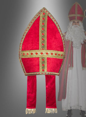 Im Mittelpunkt ist eine edle Rote Mitra-Bischofsmütze mit langen, herabhängenden Laschen zu sehen, im Hintergrund ist teilweise eine Person in einem Sankt-Nikolaus-Kostüm zu erkennen.