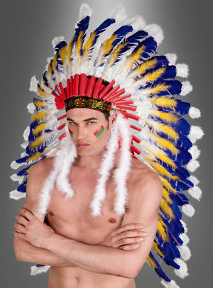 Eine Person mit nacktem Oberkörper, die den „Deluxe Häuptling Indianer Federschmuck“ trägt – einen auffälligen Kopfschmuck, der mit roten, gelben, blauen und weißen Federn verziert ist –, steht mit verschränkten Armen vor einem grauen Hintergrund mit Farbverlauf. Dieser luxuriöse Kopfschmuck unterstreicht perfekt die imposante Ausstrahlung ihres einzigartigen Indianerkostüms.