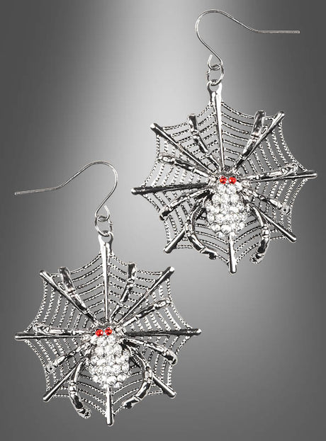 Verleihen Sie Ihrem Look einen Hauch von gruseliger Eleganz mit den „Spinnennetz“-Ohrringen – silberne Ohrringe in Spinnennetzform, verziert mit detailreich gearbeiteten Spinnen, die jeweils auffällige rote Edelsteinaugen und funkelnde klare Kristalle aufweisen. Diese Ohrringe eignen sich perfekt als Halloween-Accessoire und werden hier vor einem grauen Hintergrund mit Farbverlauf präsentiert.