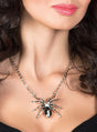 Eine Frau, die eine „Silberkette Spinne mit Edelsteinen“ mit einem großen, detailreichen Spinnenanhänger trägt, der von den Schultern bis zum Kinn reicht – perfekt als auffälliger Spinnenschmuck oder einzigartiger Halloween-Schmuck.