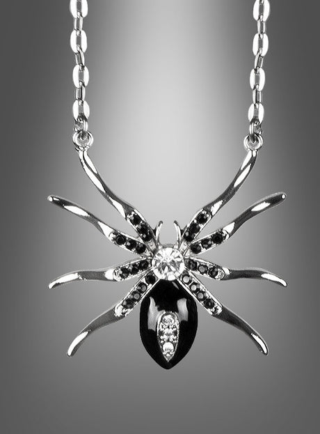 Silberkette mit Spinne und Edelsteinen: Dieser exquisite silberne Anhänger in Spinnenform, verziert mit schwarzen und klaren Edelsteinen, hängt elegant an einer Kette und ist ein auffälliges Statement-Stück unter den Spinnenschmuckstücken. Vor einem grau abgestuften Hintergrund präsentiert, ist er perfekt, um Ihrer Halloween-Schmuckkollektion einen Hauch von geheimnisvoller Eleganz zu verleihen.