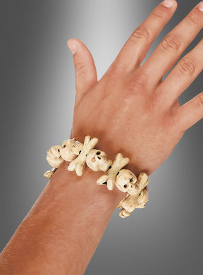 Eine Hand, die das „Cooles Voodoo Totenkopf“-Armband trägt, gefertigt aus knochenähnlichen Perlen in Form von Totenköpfen und gekreuzten Knochen, vor einem grauen Farbverlaufshintergrund – ideal, um jedes Piratenkostüm oder Halloween-Kostüm abzurunden.