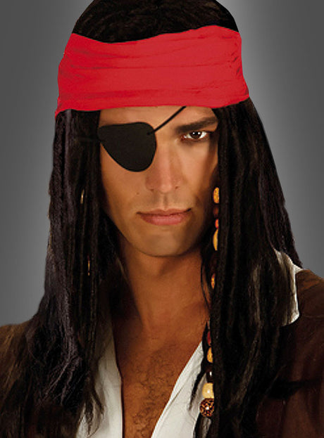 Vor einem grauen Hintergrund ist ein als Pirat verkleideter Mann mit einem roten Bandana, langen dunklen Haaren, einem braunen Hemd und einem schwarzen Piratenkostüm zu sehen, der die klassische schwarze Piraten-Augenklappe trägt.