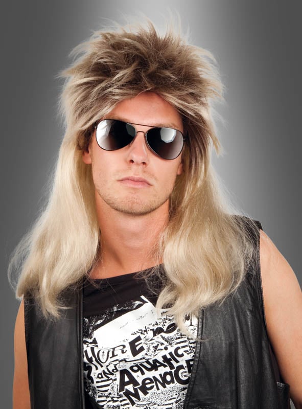 Ein Mann mit einer Pilotenbrille, einer blonden „Vokuhila“-Perücke von Rockstar, einer schwarzen Lederweste und einem T-Shirt mit Aufdruck posiert vor einem grauen Hintergrund.