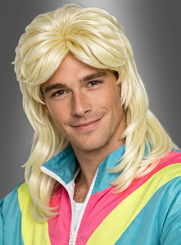 Ein Mann mit einer langen, welligen, blonden Vokuhila-Frisur, der eine Retro-Jacke in Blau, Rosa und Gelb trägt, posiert vor einem grauen Hintergrund mit Farbverlauf und präsentiert dabei die legendäre blonde Vokuhila-Perücke von Dieter Perücke.