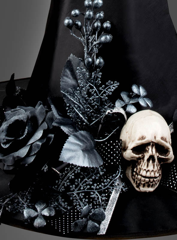 Wir präsentieren den „Halloween-Hut für Hexen mit Totenkopf-Blumen-Schmuck“ – einen auffälligen Hexenhut, verziert mit schwarzen Blumen, silbernem Laub und einem künstlichen Totenkopf, ideal, um Ihr Hexenkostüm abzurunden oder Ihre Halloween-Hut-Sammlung zu bereichern.