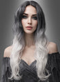 Eine Frau mit langen, welligen Haaren in einem Schwarz-zu-Weiß-Ombré-Look, die die Lockenperücke „Geisterdame weiß-schwarz“ trägt, und hellen Augen steht in einem schulterfreien dunklen Kleid vor einem grauen Hintergrund mit Farbverlauf.