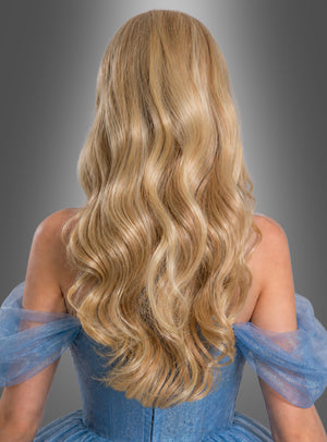 Eine Frau mit langen, welligen blonden Haaren, die wie die Langhaar-Perücke „Linda Blond“ frisiert sind, trägt ein schulterfreies blaues Kleid und wird von hinten vor einem grauen Hintergrund mit Farbverlauf fotografiert.