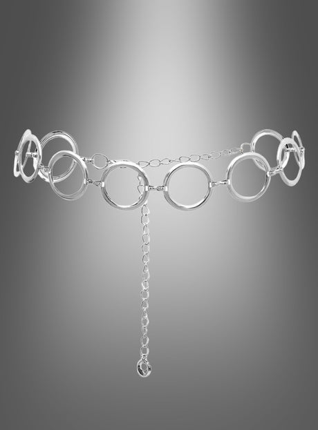Der Retro-Gürtel „Silber Hüftgürtel“ besticht durch große, miteinander verbundene Ringe und eine herabhängende Kette und ist damit das perfekte Accessoire, um Ihr Outfit im Stil der 60er- und 70er-Jahre abzurunden. Hier ist er vor einem grau verlaufenden Hintergrund abgebildet.