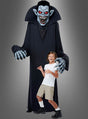 Ein Kind steht vor einer hoch aufragenden, bedrohlichen Gestalt, die das „Gigantische Vampir-Kostüm oder Deko, ca. 240 cm“ trägt – mit scharfen Zähnen, roten Augen, blauer Haut und langen Krallen – ideal für jede Halloween-Verkleidung. Die gruselige Szene spielt sich vor einem schlichten grauen Hintergrund ab.