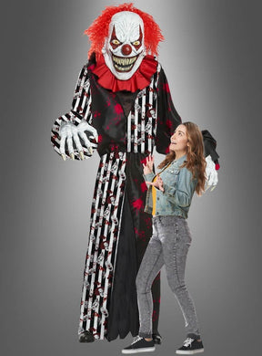 Eine imposante Gestalt im „Gigantischen Horrorclown-Kostüm oder Deko, ca. 240 cm“ – komplett mit wildem rotem Haar und messerscharfen Zähnen – ragt bedrohlich über einer erschrockenen jungen Frau in Freizeitkleidung vor einem grauen Hintergrund empor und ist damit die perfekte Halloween-Dekoration, um eine gruselige Szene zu schaffen.