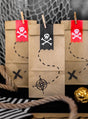 Im Set sind sechs braune Papier-„Geschenktüten Piratenparty“ enthalten, die jeweils mit Piratenmotiven wie Totenkopf-Aufklebern und Schatzkarten-Motiven verziert sind. Im Vordergrund sind Seile und goldverpackte Schokoladenmünzen zu sehen – diese Tüten eignen sich ideal als umweltfreundliche Geschenktüten für eine aufregende Piratenparty zum Kindergeburtstag.