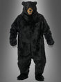 Eine Person, die ein „Schwarzbär“-Kostüm Deluxe mit Ani-Motion-Maske trägt, das durch ein naturgetreues Bärengesicht und realistische Krallen besticht, steht vor einem grauen Hintergrund mit Farbverlauf.