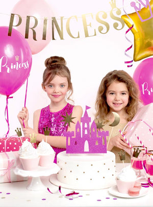 Zwei kleine Mädchen stehen bei einer Prinzessinnen-Geburtstagsfeier vor einer Torte und rosa Dekorationen, im Hintergrund sind bunte Folienballons und ein Prinzessinnen-Banner zu sehen – so entsteht mit dem 31-teiligen Prinzessinnen-Geburtstags-Partydeko-Set die perfekte Partystimmung.