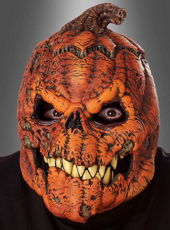Eine Person, die die Halloween-Maske „beweglicher Kürbis Ani-Motion“ trägt, mit großen gelben Zähnen, strukturierter orangefarbener Schale und hohlen Augen, vor grauem Hintergrund.