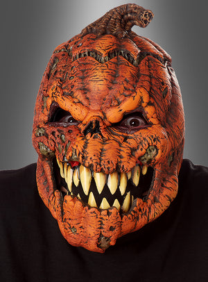 Eine Person, die die Halloween-Maske „Beweglicher Kürbis Ani-Motion“ trägt, die sich durch große gelbe Zähne, tiefe Rillen und einen verdrehten Stiel oben auszeichnet und vor einem neutralen grauen Hintergrund zu sehen ist – die perfekte Halloween-Maske für Horrorfans.