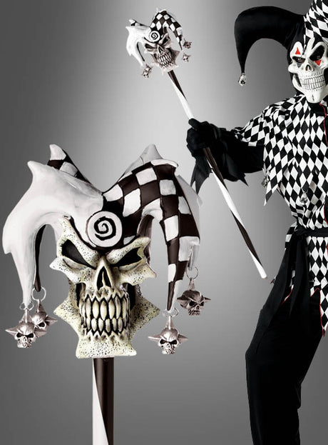 Eine Person in einem schwarz-weißen Narrenkostüm hält das Zepter „Hofnarr für gruselige Clowns“ in der Hand, das mit einem Totenkopf mit passender Narrenmütze gekrönt und mit Totenköpfen sowie karierten Mustern verziert ist – ein ideales Clownkostüm-Accessoire für alle, die auf der Suche nach einem authentischen Horrorclown-Requisit sind.