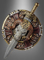 Entdecken Sie das „Fantasy-Schwert 48 cm und Schild“ – einen runden, kunstvoll verzierten Schild mit einem auffälligen Widderkopf- und Schwertmotiv, verziert mit goldenen, roten und silbernen Details vor einem grau verlaufenden Hintergrund. Ideal für Karnevalskostüme oder jede Veranstaltung zum Thema „Schwert und Schild“.