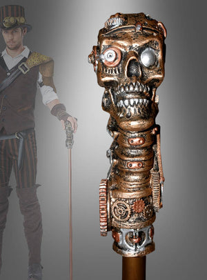 Aber sicher! Hier ist Ihr umformulierter Satz unter Verwendung der angegebenen Produktdaten: Eine Person in Steampunk-Kleidung hält einen „Gehstock Steampunk Alien“ in der Hand, dessen Spitze von einem kunstvoll verzierten metallischen Totenkopf mit Zahnrädern, Schrauben und mechanischen Details gekrönt ist – ein auffälliges Spazierstock-Accessoire, das das einzigartige Steampunk-Kostüm abrundet.
