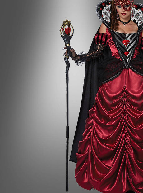 Eine Person in einem aufwendig gearbeiteten rot-schwarzen Herzkönigin-Kostüm, die eine dekorative Maske trägt und das 150 cm lange Zepter der Herzkönigin in der Hand hält, steht vor einem grauen Hintergrund mit Farbverlauf und präsentiert dabei perfekt die eleganten Accessoires des Damenkostüms.