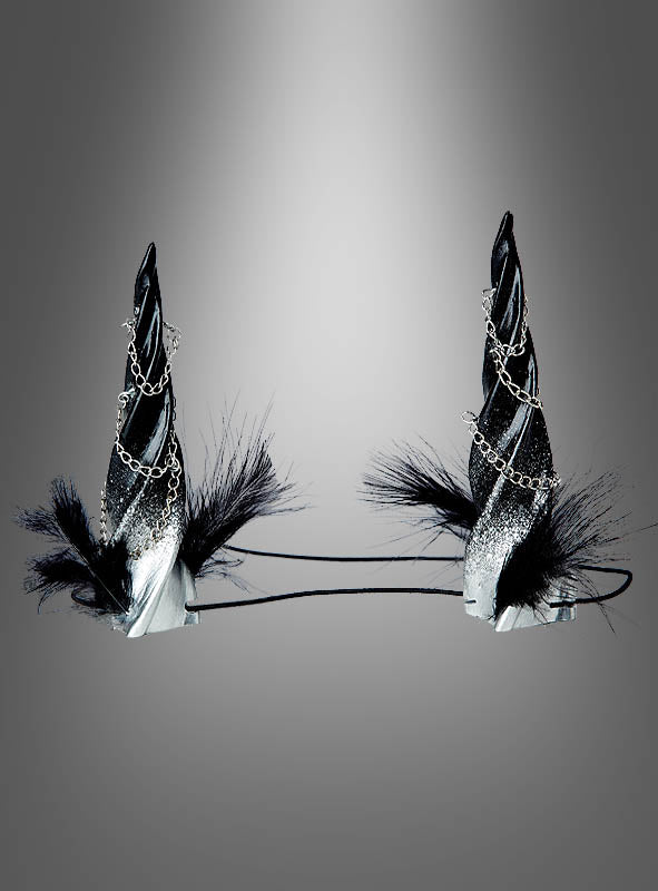 Zwei schwarze Stirnbänder „Gedrehte Hörner – Kopfschmuck für Dämonin“ mit spiralförmigen Hörnern, verziert mit silbernem Glitzer, Zierketten und schwarzen Federn – ideal, um dein Gothic-Damen-Outfit abzurunden oder als perfektes Accessoire für ein Dämonin-Kostüm – präsentiert vor einem grauen Hintergrund mit Farbverlauf.