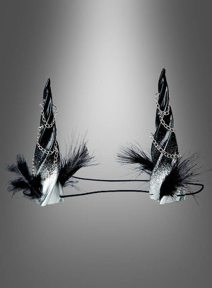 Zwei schwarze Stirnbänder „Gedrehte Hörner – Kopfschmuck für Dämonin“ mit spiralförmigen Hörnern, verziert mit silbernem Glitzer, Zierketten und schwarzen Federn – ideal, um dein Gothic-Damen-Outfit abzurunden oder als perfektes Accessoire für ein Dämonin-Kostüm – präsentiert vor einem grauen Hintergrund mit Farbverlauf.