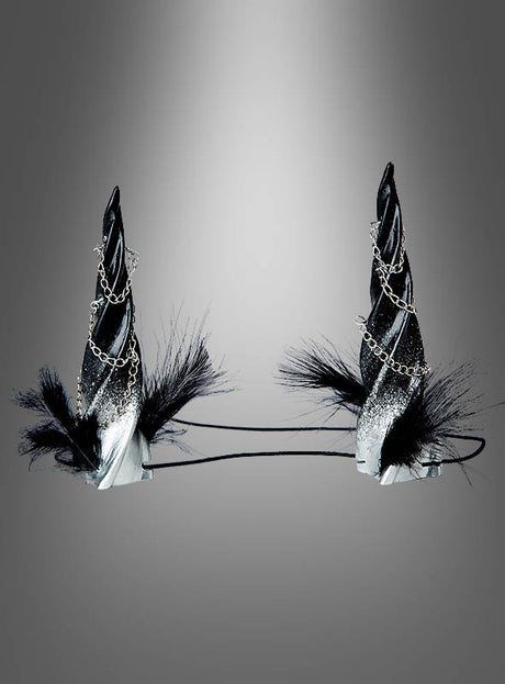 Zwei schwarze Stirnbänder „Gedrehte Hörner – Kopfschmuck für Dämonin“ mit spiralförmigen Hörnern, verziert mit silbernem Glitzer, Zierketten und schwarzen Federn – ideal, um dein Gothic-Damen-Outfit abzurunden oder als perfektes Accessoire für ein Dämonin-Kostüm – präsentiert vor einem grauen Hintergrund mit Farbverlauf.