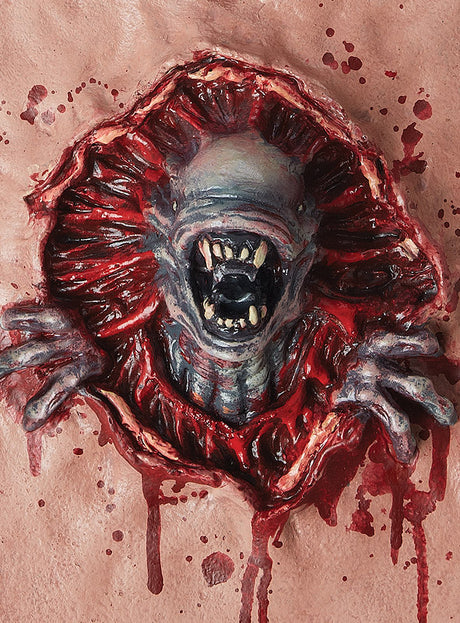 Ein Wesen mit scharfen Zähnen und Klauen bricht durch eine blutige, fleischige Oberfläche, umgeben von Blutspritzern – perfekt als „Ausserirdischer Parasit Brustteil Alien“ für dein nächstes Halloween-Kostüm für Männer oder jede andere Horror-Verkleidung.