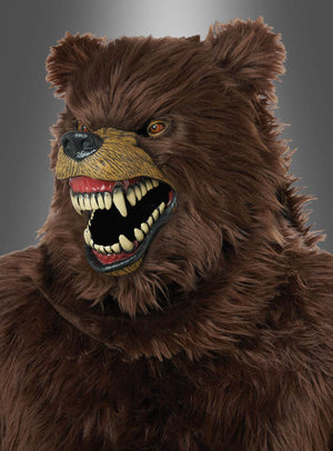 Eine Person, die eine Grizzly-Bär-Maske mit beweglichem Kiefer, scharfen Zähnen und braunem Fell trug, posierte vor einem neutralen grauen Hintergrund.