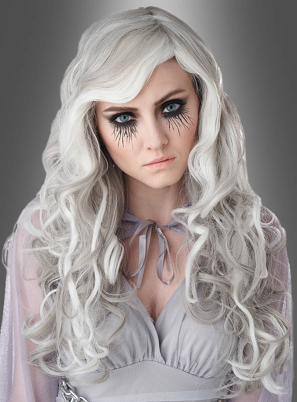 Eine Frau mit langen, welligen silbernen Haaren, die mit der Perücke „Leuchtende Lockenperücke Geisterfrau“ frisiert sind, mit dramatischem schwarzem Augen-Make-up, das an Streifen erinnert, und einem hellgrauen Outfit, die vor einem grauen Hintergrund posiert.