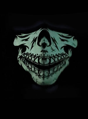 Auf schwarzem Hintergrund ist ein leuchtend grüner Totenkopf mit übertrieben großen Zähnen und Rissen abgebildet, der an die „Baumwolle Gesichtsmaske Skelett Glow in the Dark“ erinnert und so einen unheimlichen Effekt erzeugt.