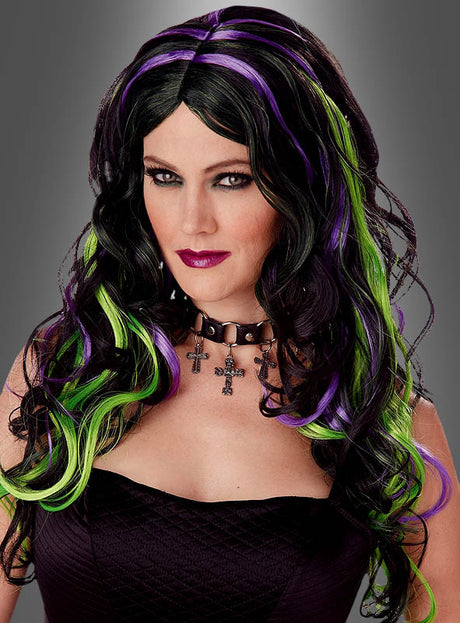 Eine Frau mit langen, welligen schwarzen Haaren, die mit violetten und grünen Strähnchen durchzogen sind, in einem schwarzen, trägerlosen Oberteil, mit dunklem Lippenstift und einer Choker-Halskette mit Kreuzanhängern vor grauem Hintergrund – perfekt, um dein Gothic-Kostüm zu vervollständigen oder als „Magische Hexe“-Perücke zu stylen.