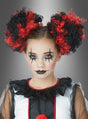 Ein junges Mädchen in einem Clownskostüm trägt eine auffällige schwarz-rote Lockenfrisur, die mit „Lockige Haarteile für Clownskostüm“ gestaltet wurde, sowie passende Pompons. Abgerundet wird ihr Look durch dunkles Augen-Make-up, schwarzen Lippenstift und einen Rüschenkragen, während sie vor einem grauen Hintergrund direkt in die Kamera blickt.