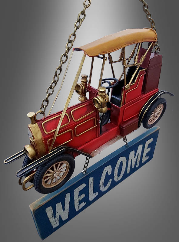 Das dekorative Schild „20er Jahre Türschild Oldtimer Willkommen 30 cm“ zeigt ein rotes Oldtimer-Modell im Vintage-Stil mit einem an Ketten aufgehängten „WELCOME“-Schild vor einem grauen Farbverlaufshintergrund – ideal als Vintage-Oldtimer-Blechschild, um Ihre 20er-Jahre-Partydekoration aufzuwerten.