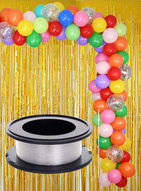 Vor einem schimmernden Hintergrund mit goldenen Fransen steht ein farbenfroher Ballonbogen (Ballongirlande), während im Vordergrund eine Rolle „Angelschnur Deko Befestigung 100 m“ gut sichtbar platziert ist – ideal, um Ihrer Partydekoration eine raffinierte Note zu verleihen.