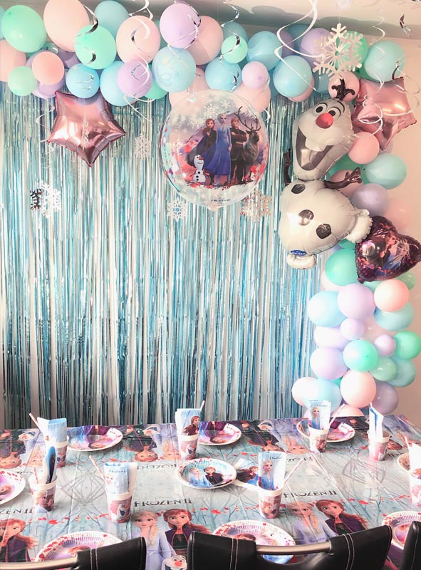 Veranstalten Sie eine bezaubernde Geburtstagsparty zum Thema „Die Eiskönigin“ mit blauen und lila Luftballons, Luftballons in Stern- und Figurenform, einem schimmernden Hintergrund und Geschirr mit den beliebten Figuren aus „Die Eiskönigin“. Verleihen Sie der Feier einen besonders magischen Touch, indem Sie den Orbz-Luftballon „Die Eiskönigin“ (40 cm) als atemberaubendes Herzstück Ihrer Dekoration einsetzen.