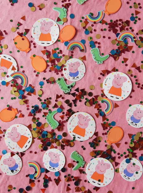 Verschiedene Peppa-Wutz- und Dinosaurier-Papierausschnitte, bunte Regenbögen und metallische Peppa-Wutz-Konfetti-Streuteile, die auf einem rosa Untergrund verstreut sind, sorgen für die perfekte Party-Stimmung. Diese verspielte Peppa-Pig-Tischdekoration wird durch glänzende Peppa-Wutz-Konfetti-Streuteile aufgepeppt und sorgt so für eine ausgelassene Feststimmung.