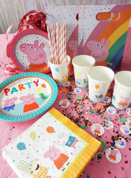 Aber sicher! Hier ist der überarbeitete Satz unter Verwendung der angegebenen Produktdaten: Partyzubehör zum Thema „Peppa Pig“, arrangiert auf einem rosa Tisch, darunter Peppa-Pig-Tischdekoration wie Teller, Becher, Servietten, Geschenktüten, Papierstrohhalme und „Peppa Wutz“-Konfetti-Streuteile mit Comicfiguren und Luftballons.